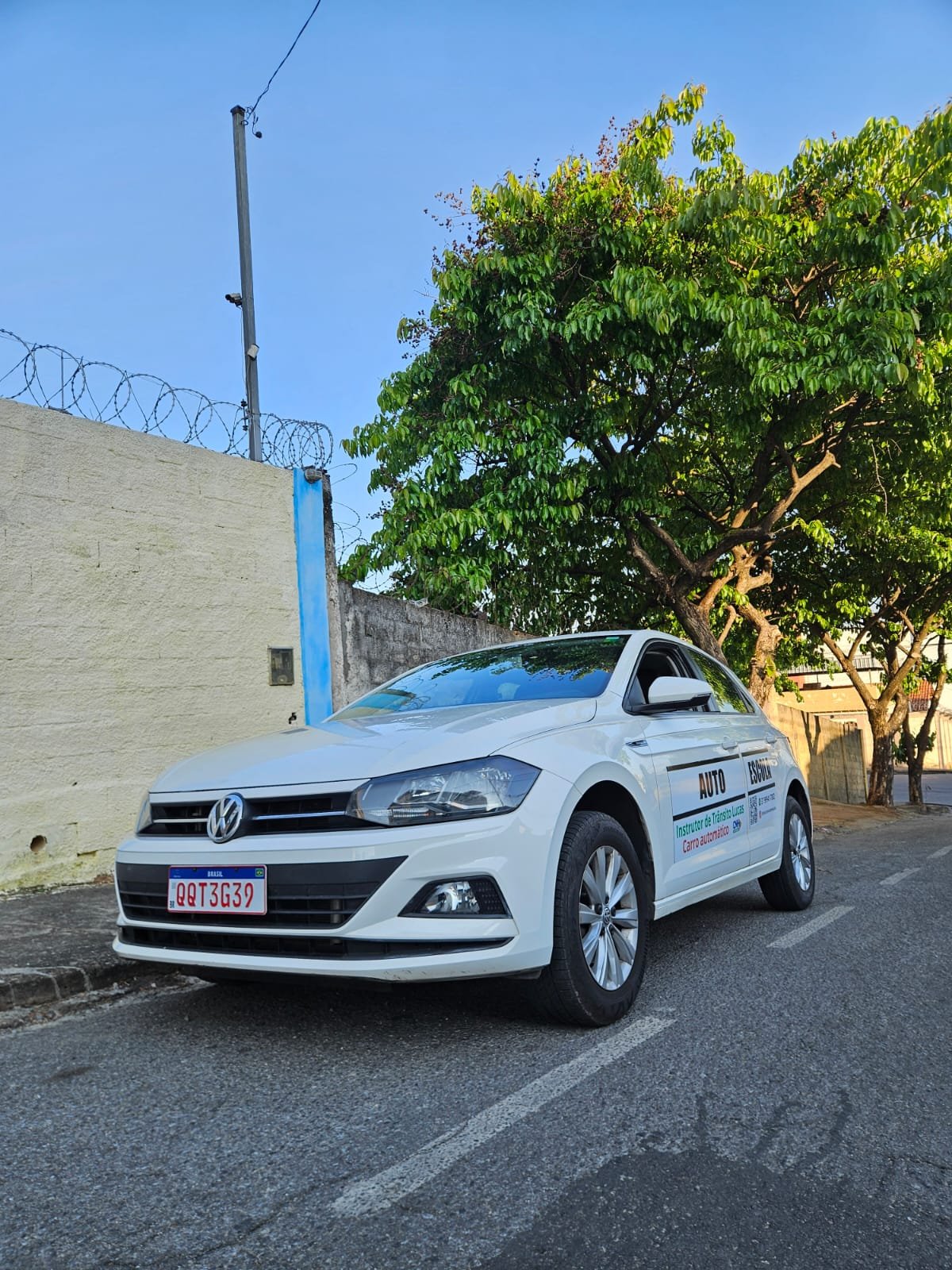 Volkswagen Polo automatico visto de frente, com identificacao de autoescola